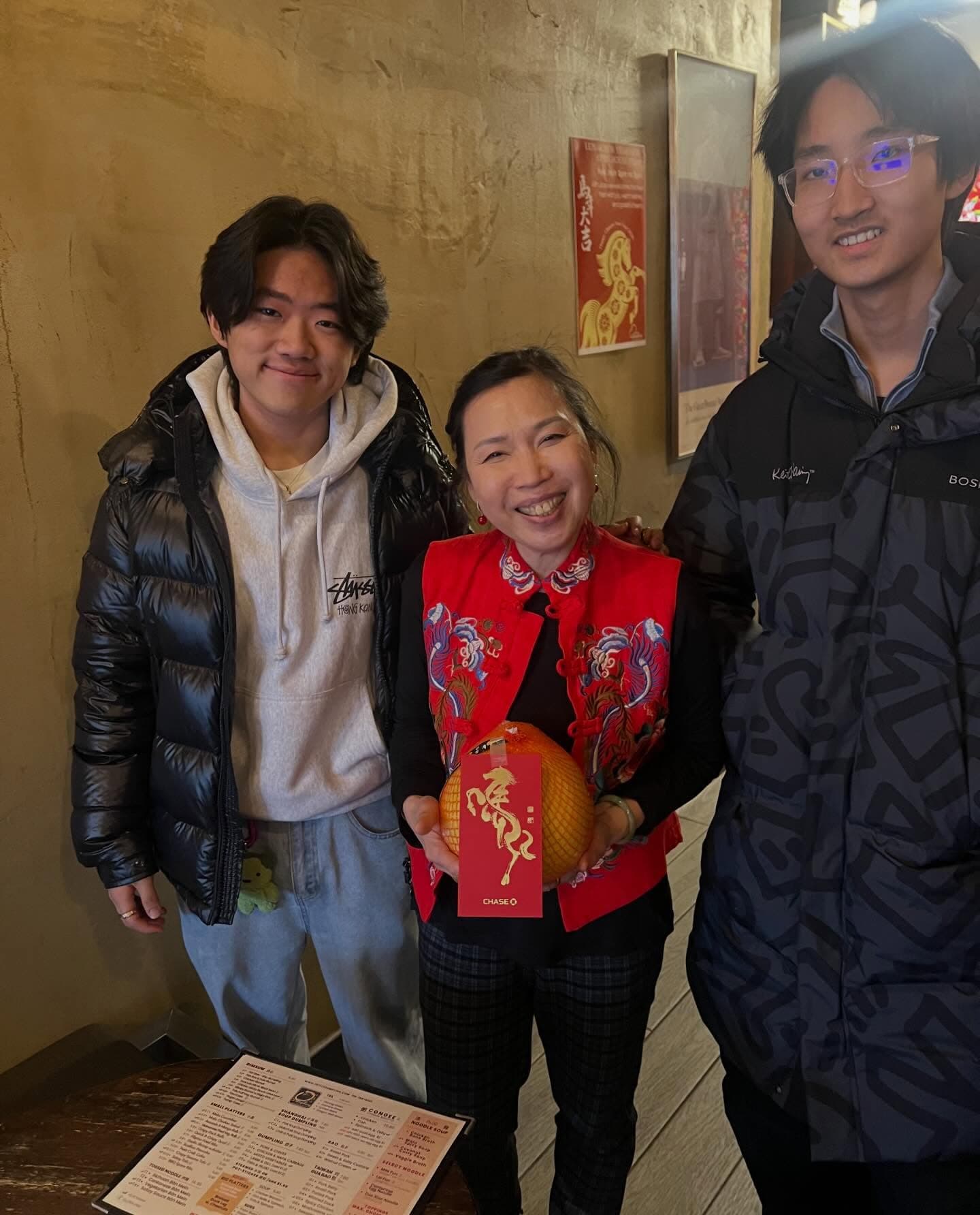 Two Novus students with a local restaurant owner